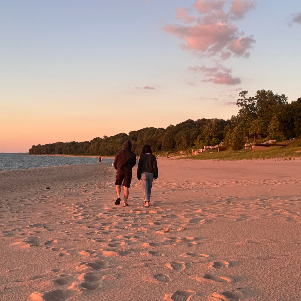 Couple walking a lakeshore beach at sunset