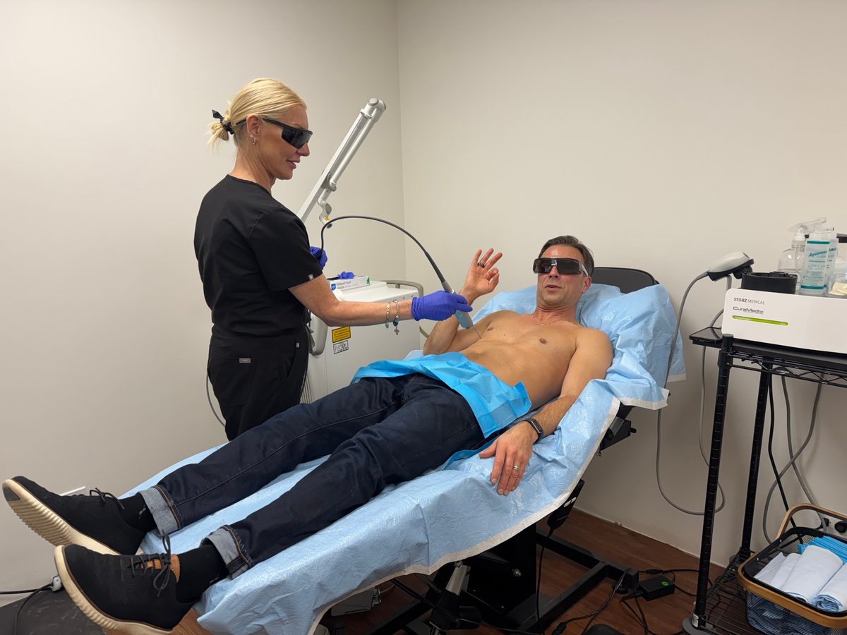 Izabella Monchunski, Licensed Aesthetician at TRU Integrative Wellness, performing laser hair removal on a male patient